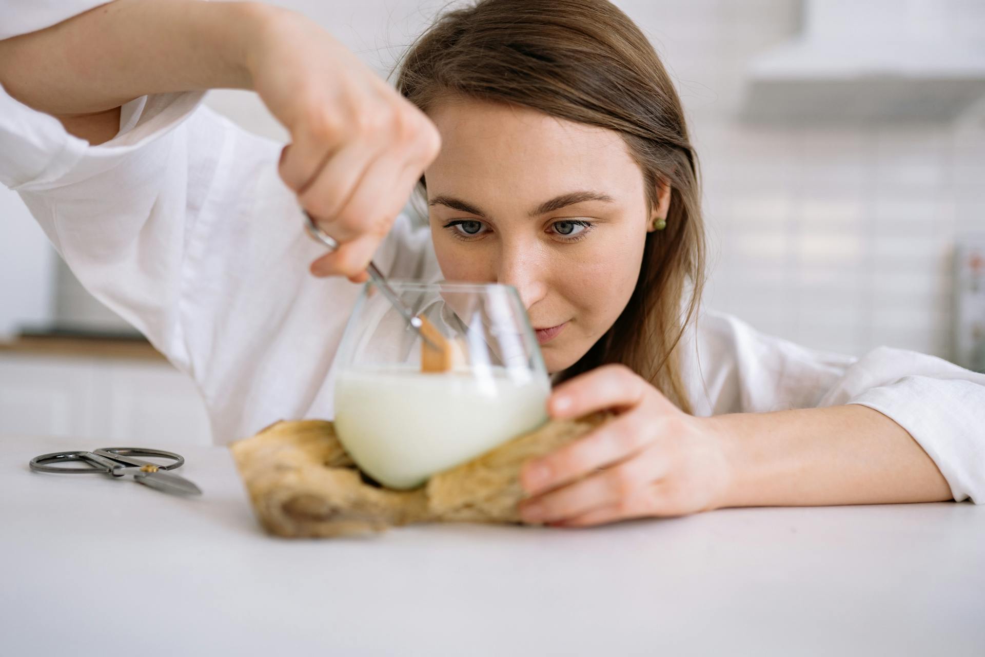 woman cutting a wood wick candle